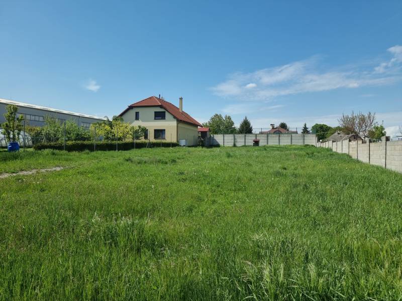 PREDAJ - Krásny rovinatý pozemok 1090 m2 - Cabaj-Čápor - Pozemky - bývanie v Cabaji-Čápore s trávnatou plochou a domom v pozadí.