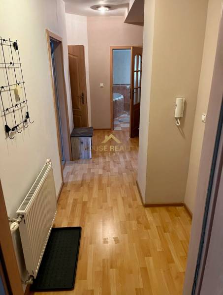 Predaj zariadený 2 izbový byt, Záhradnícka ulica,Bratislava II Ružinov - Chodba v 2-izbovom byte s drevenou podlahou, vešiakom, vstupom do kúpeľne.