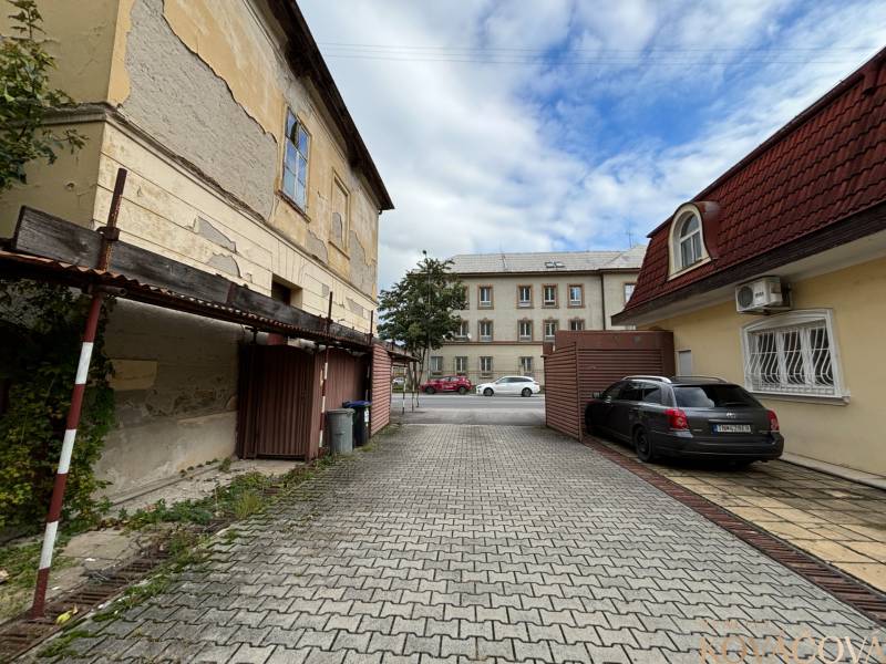 Na predaj pozemok 2269 m² so stavebným povolením na bytový dom,Trenčín - Staré budovy a zaparkované auto na M.R. Štefánika v Trenčíne, Výstavba bytov.