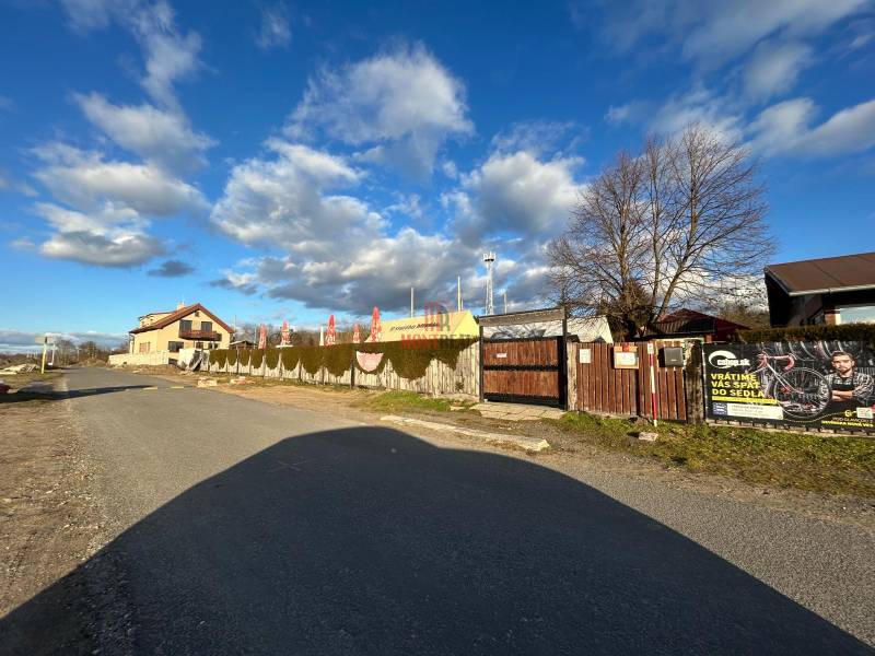 Pozemok s gastronomickým zariadením, kompletné zariadenie a zázemie - Ulica Devinske jazero v Bratislave, Gastro priestory obklopené plotom a reklamnými bannery.