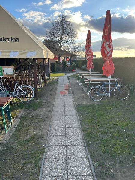 Pozemok s gastronomickým zariadením, kompletné zariadenie a zázemie - Chodník vedľa gastro priestorov s bicyklami a slnečníkmi, Devínska Nová Ves, Devínske jazero.