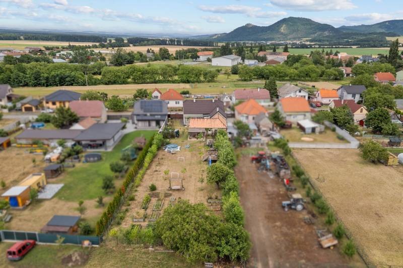 Ponúkame na predaj 4 izb. rodinný dom po kompletnej rekonštrukcii  - Letecký pohľad na záhrady a domy na ulici Hoštáky v Sološnici.