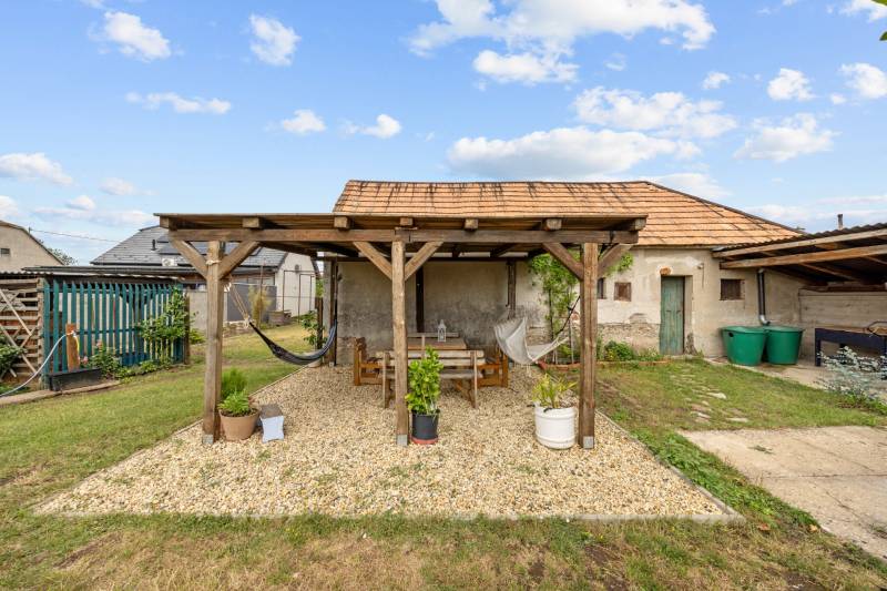 Ponúkame na predaj 4 izb. rodinný dom po kompletnej rekonštrukcii  - Drevená pergola s lavičkou a hojdacími sieťami na záhrade rodinného domu v Sološnici, Hoštákoch.