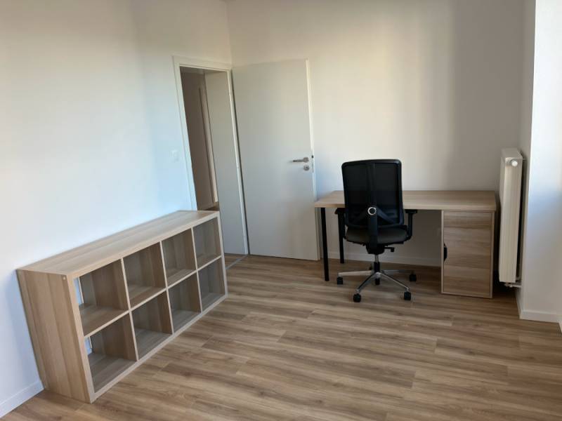 Nový priestranný 3iz. byt s klimatizáciou, balkónom a parkovaním. - Izba v 3-izbovom byte s pracovným stolom, stoličkou a policovým regálom.