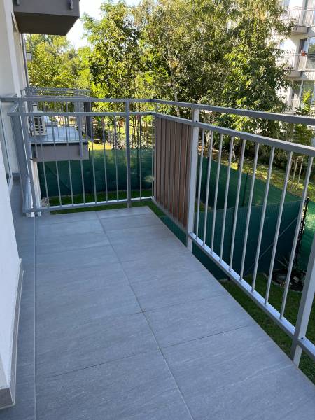 Nový priestranný 3iz. byt s klimatizáciou, balkónom a parkovaním. - Balkón 3-izbového bytu na ulici Mahulanka v Pezinku s výhľadom na zeleň.