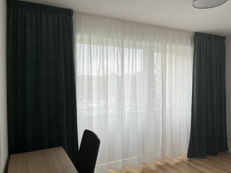 Nový priestranný 3iz. byt s klimatizáciou, balkónom a parkovaním. - Závesy a stolík v 3-izbovom byte, drevená podlaha, prirodzené svetlo.