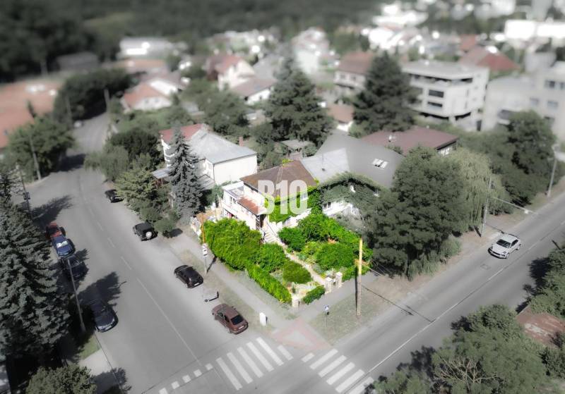 Predaj rodinného domu, Bratislava I - Rodinný dom v lokalite Bratislava - Staré Mesto, obklopený zeleňou a cestou s autami.