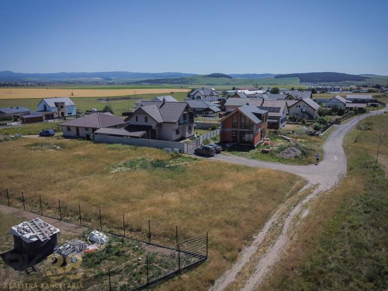 Stavebný pozemok v skvelej lokalite pod Tatrami - Pozemky na bývanie v Mlynici s rodinnými domami a vidieckou krajinou v pozadí.