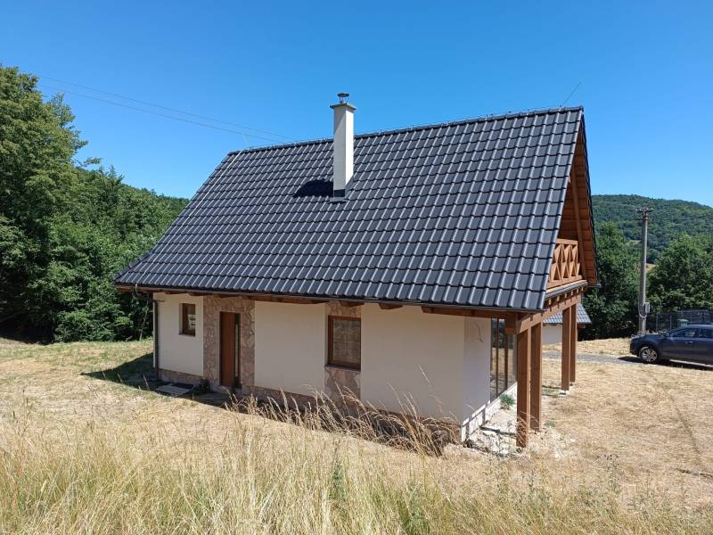 Na predaj chata novostavba  pri Novej Bani - Chata v Horných Hámroch s drevenou strechou a verandou, obklopená prírodou.