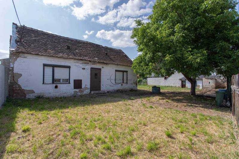 NA PREDAJ pekný slnečný stavebný pozemok na Športovej ulici v Gajaroch - Dom na pozemku pre bývanie v Gajaroch na Športovej ulici, s okolitou zelenou plochou.
