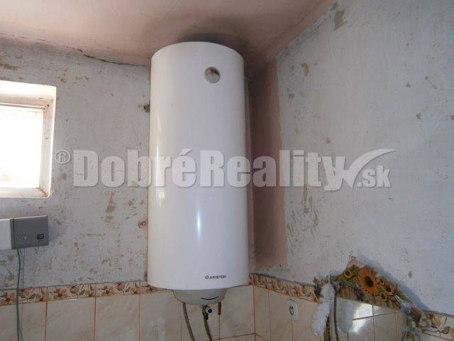 Na predaj rodinný dom v obci Rúbaň, okres Nové Zámky za výhodnú cenu! - Elektrický bojler v rodinnom dome s obkladom na stene a malým oknom.