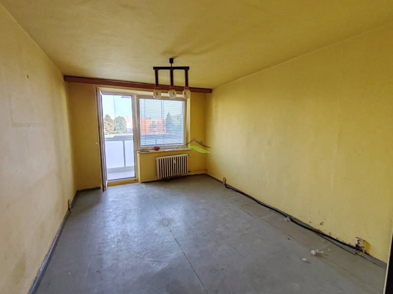 Komfortné bývanie s balkónom na Sídlisku Juh – váš nový domov čaká! - Žltá obývacia izba s balkónom v 3-izbovom byte.