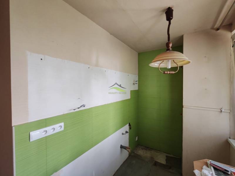 Komfortné bývanie s balkónom na Sídlisku Juh – váš nový domov čaká! - Prázdna kuchyňa so zelenými obkladmi a osvetlením v 3-izbovom byte.