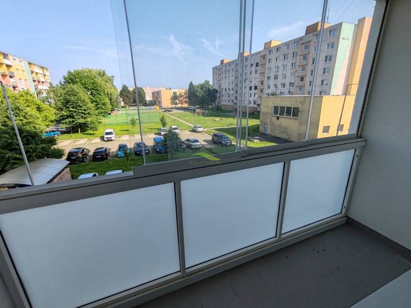 Komfortné bývanie s balkónom na Sídlisku Juh – váš nový domov čaká! - Balkón s výhľadom na parkovisko a zeleň v Sídlisku Juh, Vranov nad Topľou.