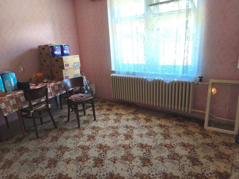 Rodinný dom Obsolovce - Izba v rodinnom dome s kobercovým vzorom a stolom so stoličkami.