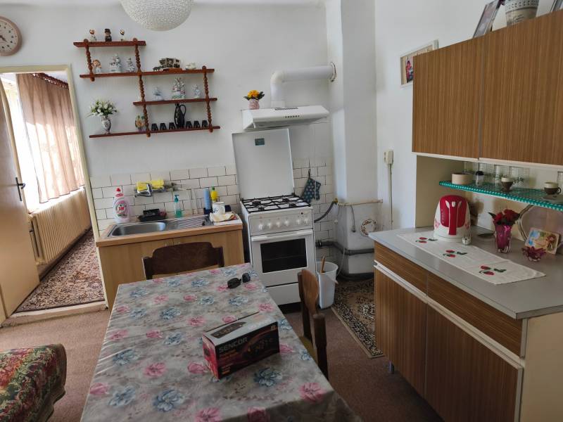 Rodinný dom Obsolovce - Kuchyňa v rodinnom dome s jedálenským stolom, linkou a dekoráciami na poličke.