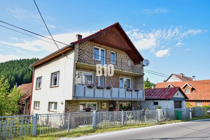 Predaj rodinného domu, Čadca - Rodinný dom v Turzovke s kvetmi na balkóne a satelitnou anténou.