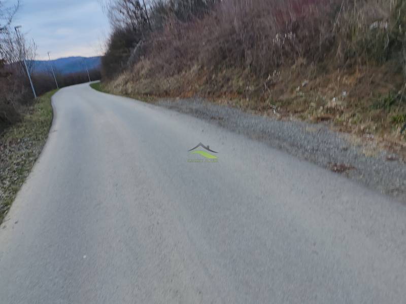 Pozemok snov pri vodnej ploche Domaša – Holčíkovce, Eva - Cesta na Rekreačné pozemky v Holčíkovciach, ulica Eva, obklopená prírodou a kopcami.
