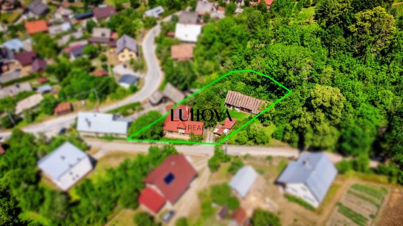 Starší rodinný dom – Ihrište_Púchov  - Letecký pohľad na rodinný dom v Púchove obklopený zelenými záhradami a ulicou.