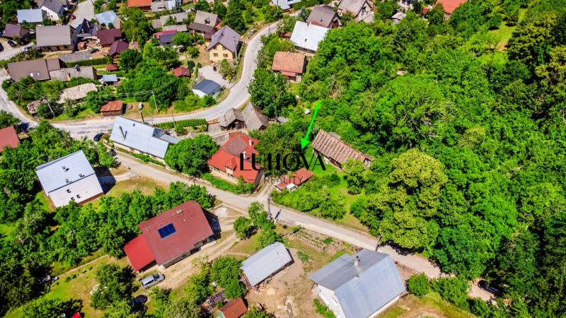 Starší rodinný dom – Ihrište_Púchov  - Letecký pohľad na rodinné domy a okolie v Púchove, obkolesené zeleňou a cestami.