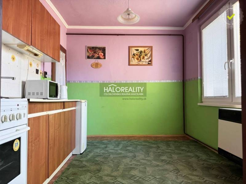 Predaj, jednoizbový byt Radvaň nad Dunajom, len 120 ... - Kuchyňa v 1-izbovom byte s drevenou linkou, zeleným kobercom a dekoráciami na stenách.
