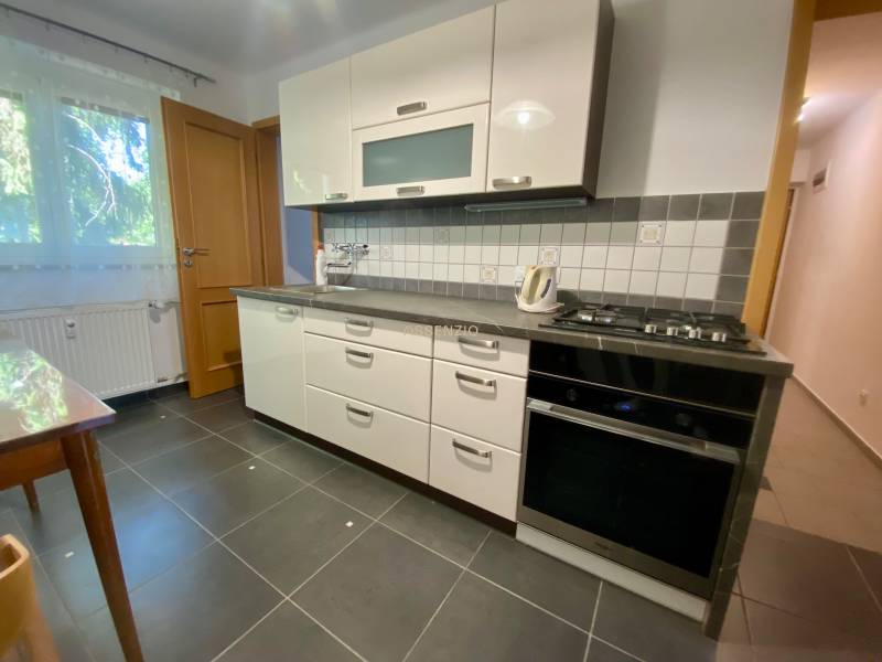- PREDAJ - Priestranný 2i byt vo vyhľadávanej lokalite - Kuchyňa v 2-izbovom byte s bielymi skrinkami a čiernymi spotrebičmi.