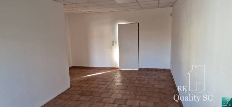 NA PRENÁJOM –  priestor na služby a kancelárie v úplnom centre mesta S - Interiér budovy s bielymi stenami a dlažbou na podlahe.