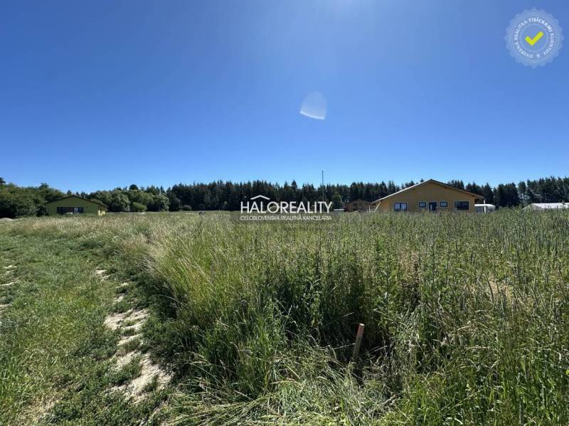 Predaj, pozemok pre rodinný dom   625 m2 Jamník - dr... - Pozemok na bývanie v Jamníku s trávnatou plochou a budovami v pozadí.