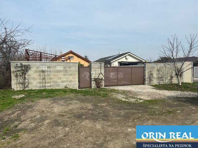 Zálesie orná pôda na predaj 3237m2 /21,- Eur / m2 - V Zálesí na ulici Domky je zobrazená uzavretá brána a betónový plot obklopujúci poľnohospodárske a lesné pozemky.