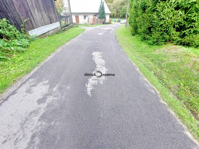 NA PREDAJ drevená chalúpka v Motyčkách  - Úzka cesta obkolesená zeleňou a domom na ulici Motyčky vedie k chate.