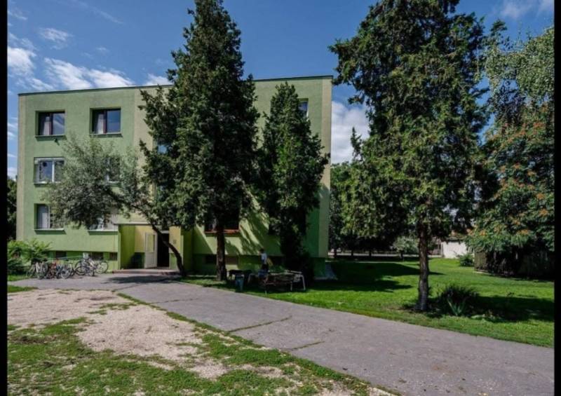 NA PRENÁJOM 1,5-IZBOVÝ BYT S PIVNICOU, ČÍČOV - Bytovka obklopená stromami v Číčove, vedľa asfaltovej cesty a bicyklov.