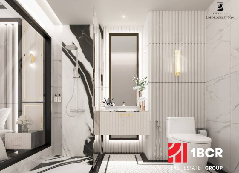 2 IZBOVÝ APARTMÁN (2 SPÁLNE + 1 OBÝV. IZBA)  EMBASSY LIFE PATTAYA - Elegantná biela kúpeľňa v 3-izbovom byte so sprchovacím kútom a zrkadlom.