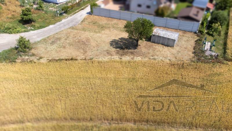  Stavebný pozemok pri jazere Nové Košariská  - Pokojný pozemok na bývanie v Dunajskej Lužnej, s prístreškom a stromom.