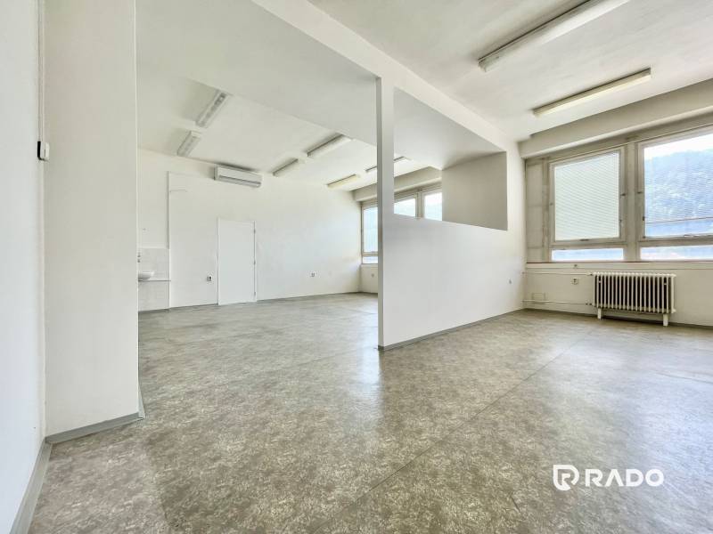 Kancelárie na prenájom 60m2, budova Fischer TireTech, TN - Kancelárie s prázdnym priestorom, bielymi stenami, veľkými oknami a radiátorom.