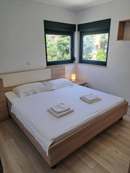 CHORVÁTSKO - Zariadený apartmán, 1. rad od mora - MANDRE, ostrov PAG - Spálňa v 3-izbovom byte s dvojlôžkovou posteľou, oknami a nočným stolíkom.