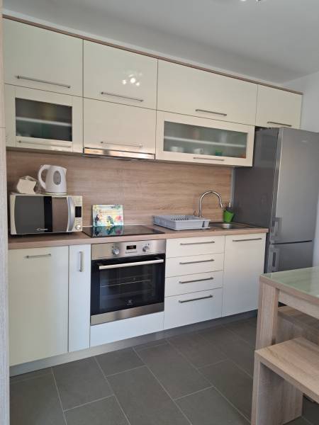 CHORVÁTSKO - Zariadený apartmán, 1. rad od mora - MANDRE, ostrov PAG - Kuchyňa v 3-izbovom byte so svetlými skrinkami a nerezovými spotrebičmi.