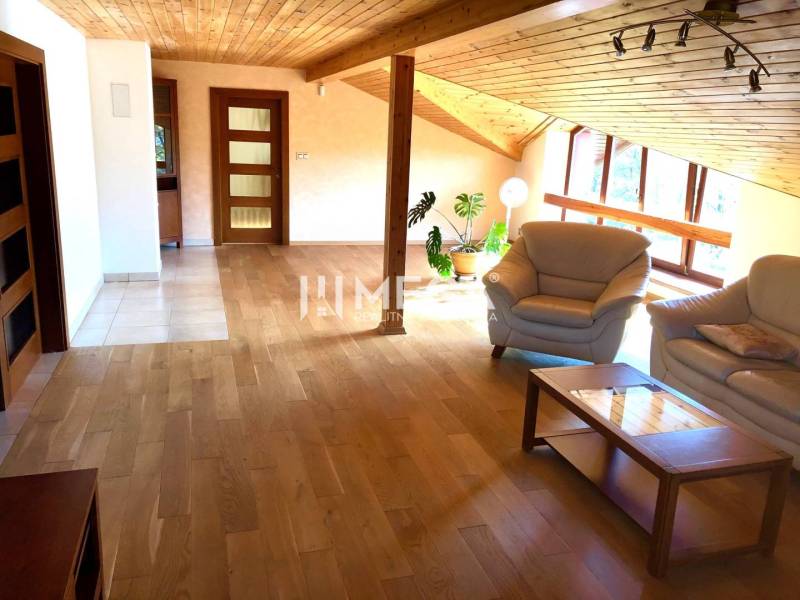 EXKLUZÍVNE NA PRENÁJOM VEĽKOMETRÁŽNY BYT 157M²  v meste HUMENNÉ - Podkrovný obývací priestor s drevenou podlahou a sedacou súpravou v 3-izbovom byte.