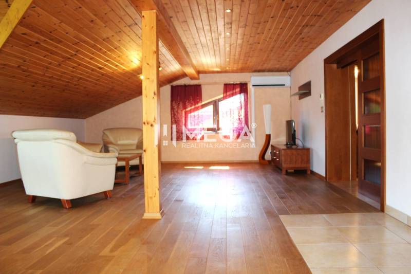 EXKLUZÍVNE NA PRENÁJOM VEĽKOMETRÁŽNY BYT 157M²  v meste HUMENNÉ - Podkrovný interiér v 3-izbovom byte s dreveným stropom a koženým sedením.