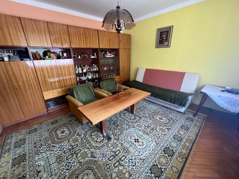 RD Drahovce - Obývacia izba v rodinnom dome s nábytkom, kobercom a obrazom na stene.