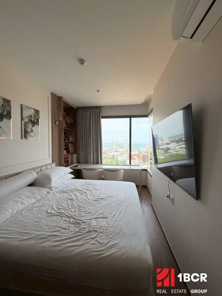 2 SPÁLŇOVÝ APARTMÁN ONCE PATTAYA - Svetlá spálňa v 3-izbovom byte s výhľadom, posteľou a televíziou na stene.