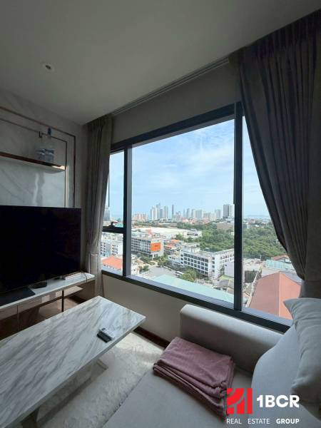 2 SPÁLŇOVÝ APARTMÁN ONCE PATTAYA - Obývačka 3-izbového bytu s výhľadom na mesto, pohodlným gaučom a TV stolíkom.