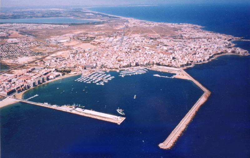 TORREVIEJA - UVÁDZACIE CENY ZA NOVOSTAVBU len 300 metrov od mora - Letecký pohľad na pobrežie mesta Torrevieja s prístavom a okolitou krajinou.