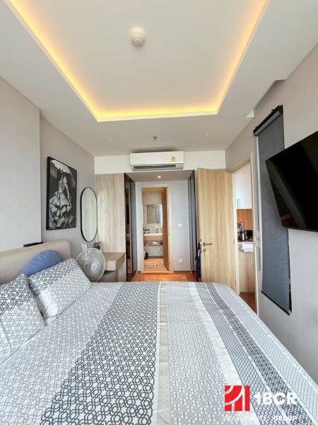 2 SPÁLŇOVÝ APARTMÁN ONCE PATTAYA - Spálňa 3-izbového bytu so vzorovanými obliečkami, zrkadlom a klimatizáciou.