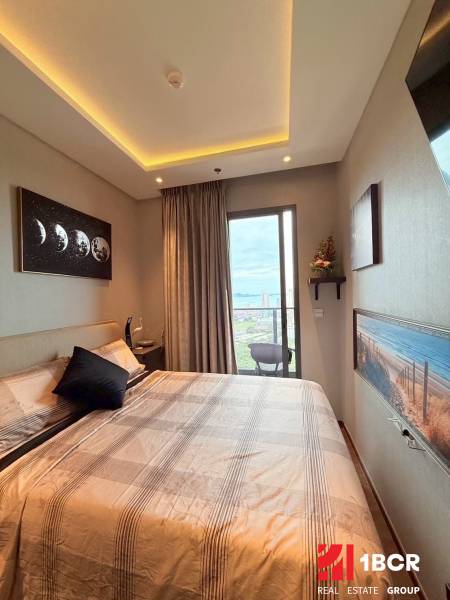 2 SPÁLŇOVÝ APARTMÁN ONCE PATTAYA - Spálňa v 3-izbovom byte s balkónom, veľkou posteľou a umeleckými obrazmi.
