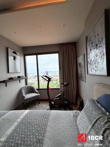2 SPÁLŇOVÝ APARTMÁN ONCE PATTAYA - Spálňa v 3-izbovom byte so stacionárnym bicyklom a výhľadom na mesto.
