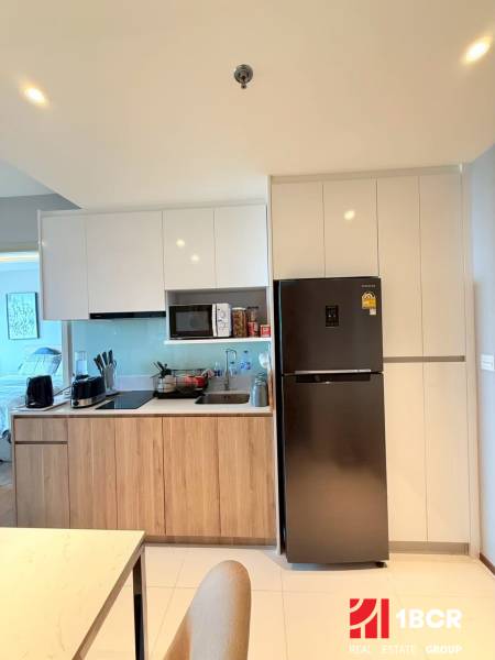 2 SPÁLŇOVÝ APARTMÁN ONCE PATTAYA - Kuchyňa v 3-izbovom byte s drevenými skrinkami a chladničkou.