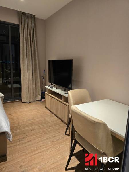 ŠTÚDIO ONCE PATTAYA - Interiér 1-izbového bytu so stolom, stoličkami, televízorom a závesmi. Bez spomínania mesta.