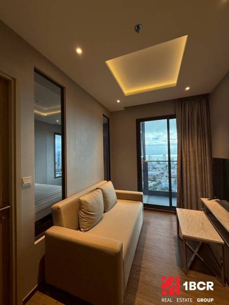 2 SPÁLŇOVÝ APARTMÁN ONCE PATTAYA - Obývacia izba v 3-izbovom byte so sedačkou, televíziou a výhľadom na mesto.