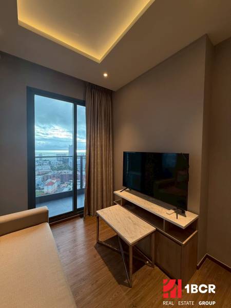 2 SPÁLŇOVÝ APARTMÁN ONCE PATTAYA - Obývačka v 3-izbovom byte s pohovkou, TV stolíkom a výhľadom na mesto.