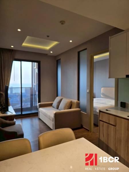 2 SPÁLŇOVÝ APARTMÁN ONCE PATTAYA - Obývacia izba v 3-izbovom byte s pohovkou, výhľadom a kuchynským pultom.